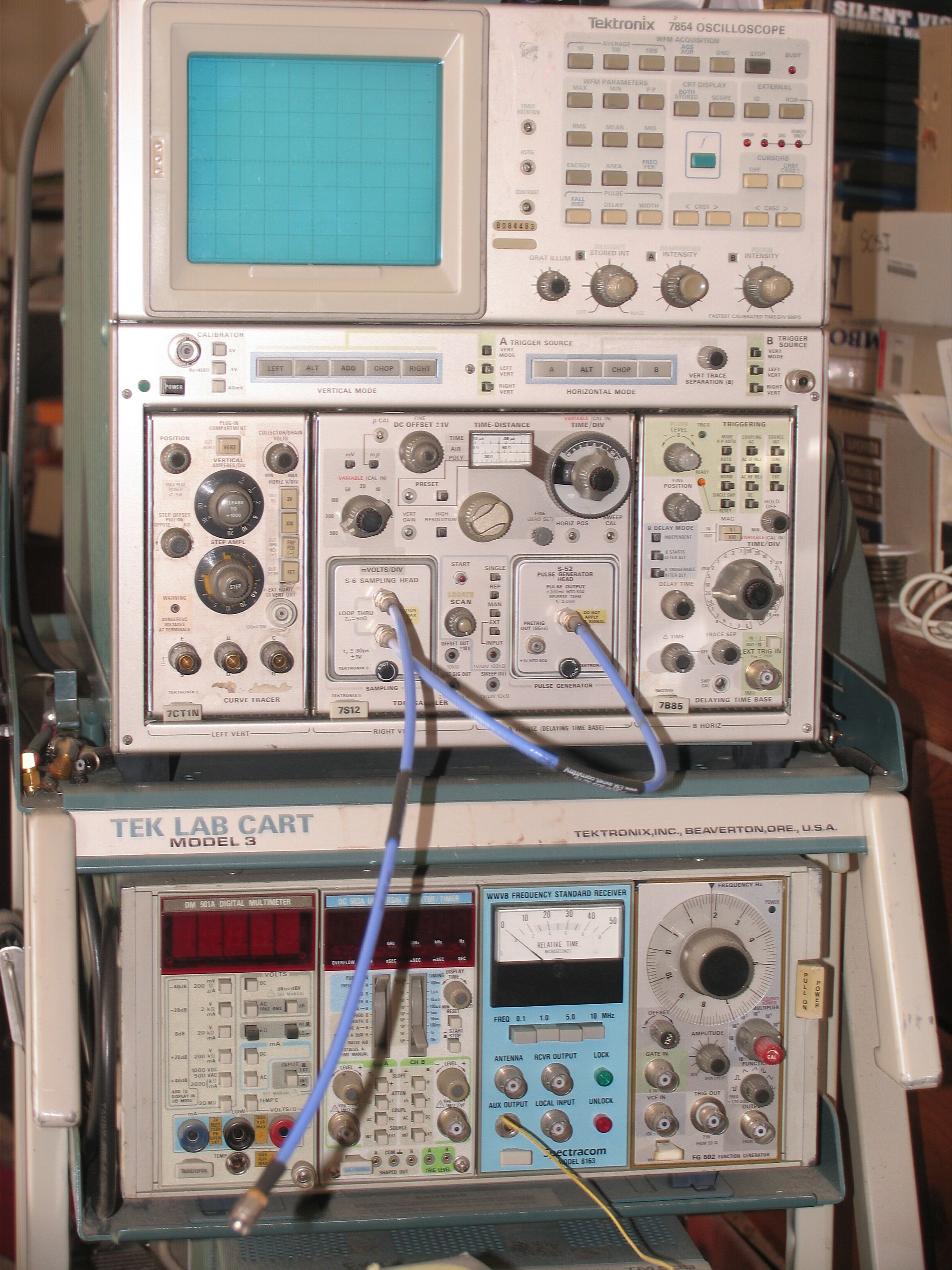 Tektronix 7854 on lab cart with four smaller measurement and test devices underneath